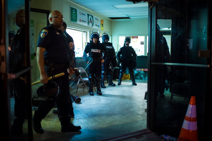 Officers gear up before the 10 p.m. curfew near the intersection of West North Avenue and Pennsylvania Avenue as protestors walk for Freddie Gray on April 30, 2015. 