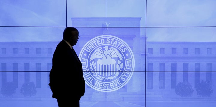 A security guard walks in front of an image of the Federal Reserve following the two-day Federal Open Market Committee (FOMC) policy meeting in Washington, March 16, 2016.