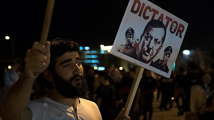 An attendee of the Armenian Genocide commemoration in downtown Beirut holds a placard depicting Turkish President Recip Teyyip Erdogan as Hitler.