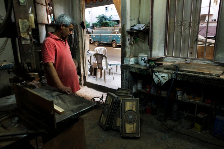 George, from Syria, admires a completed set of backgammon boards as he pauses between work. He is amongst the lucky few to have a stable income.