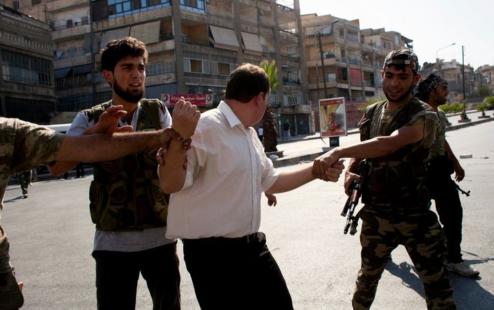 Shabiha extort some refugees for money or information, and threaten to harm the refugees' families back home, Davies said. Free Syrian Army fighters arrest an alleged shabiha member in Aleppo.