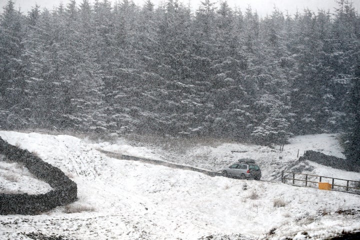 A car drives through snow near Nenthead in Cumbria