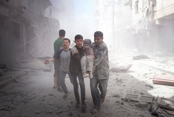 People carry an injured boy after airstrikes on Aleppo on Thursday. Nearly 250 civilians have died in nine straight days of bombardments on the city.