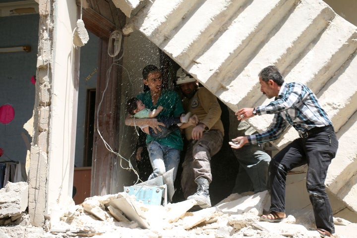 Syrians evacuate a toddler from a destroyed building in Aleppo on Thursday. Taking full control of the city would be a major boost for the regime of President Bashar Assad.