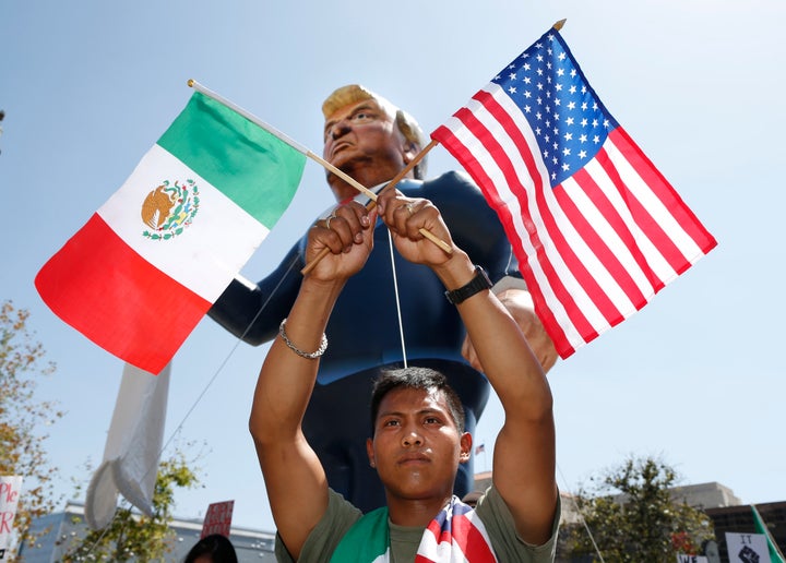 Valente Martinez, 22, marches with Mexican and U.S. flags under an inflatable effigy of Republican presidential candidate Donald Trump during an immigrant rights May Day rally in Los Angeles, California.