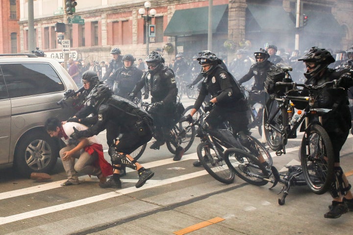 Police officers detain a protester during anti-capitalist protests following May Day marches in Seattle, Washington.