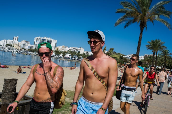 Tourists walk the promenade at Sant Antonio beach in Sant Antoni, near Ibiza, where temperatures will be lower than London this weekend 