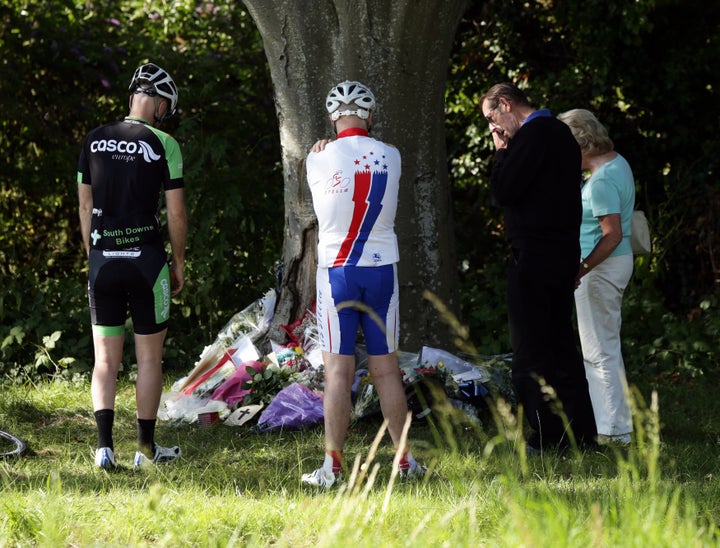 <strong>Cyclists look at floral tributes to Donald Lock at the scene</strong>
