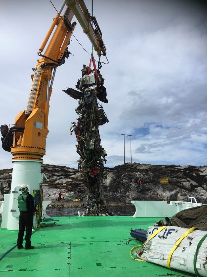 The body of the helicopter is lifted into a rescue vessel