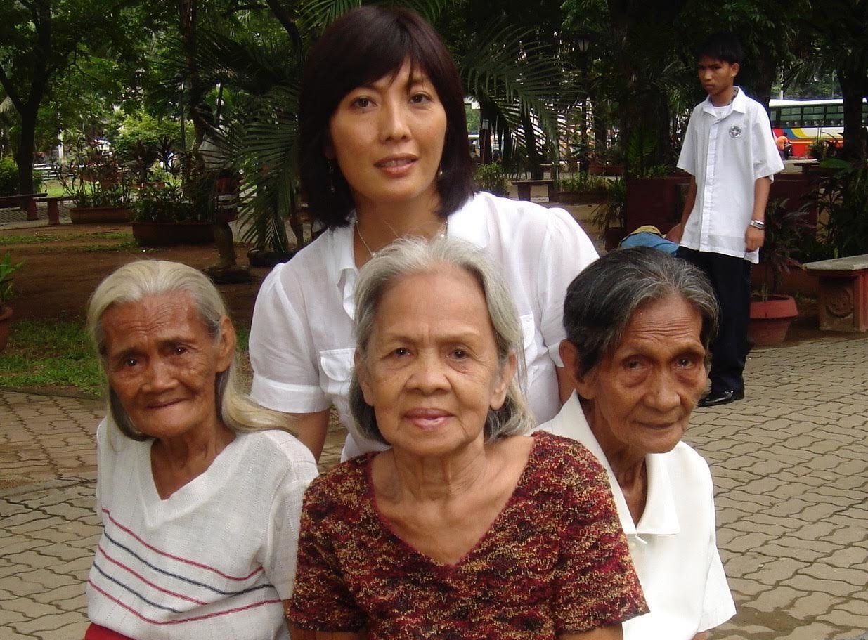 Writer M. Evelina Galang poses behind Piedad Nobleza, Dolores Molina and Josefa Villamar<em><strong> </strong></em>on July 12, 2007. The three women survived imprisonment by the Imperial Japanese Army during World War II.