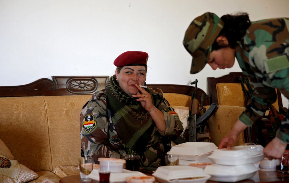 Nauzad smokes a cigarette after lunch. Her husband wanted to pay smugglers to take them to Europe. She has lost contact