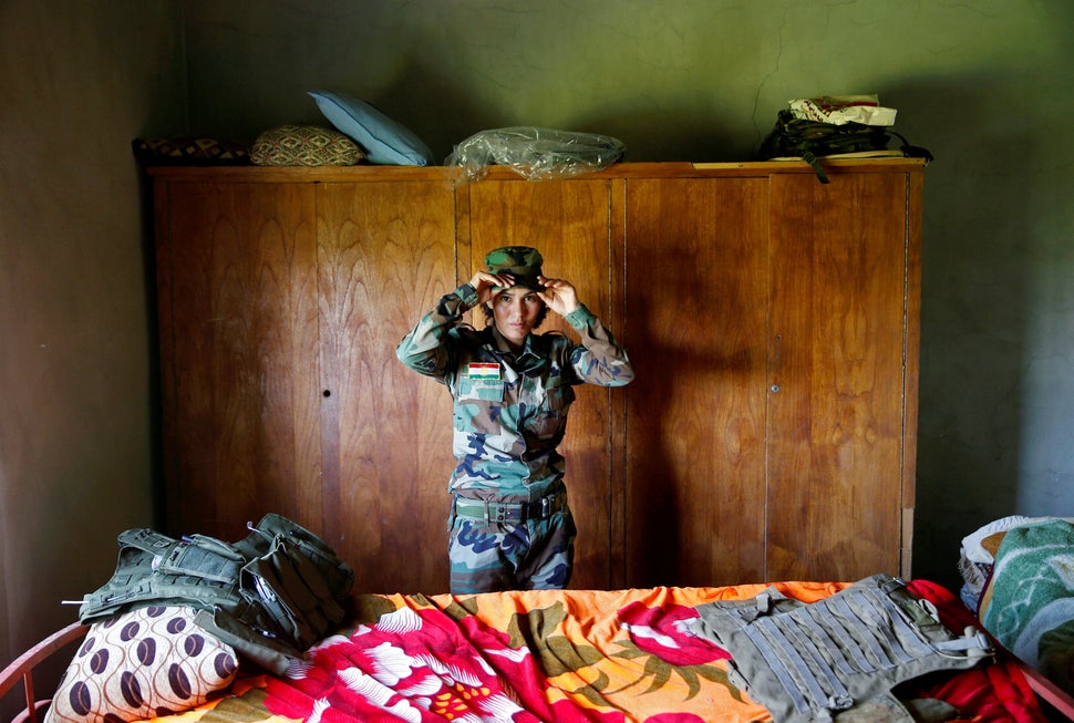 Dahir adjusts her cap in a bedroom near the front line. "They took eight of my neighbors and I saw they were killin