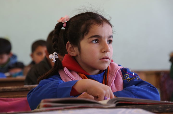 A Kurdish student listens as her teachers speaks during a lesson at the Musa Bin Nusayr school in the northeastern Syrian cit