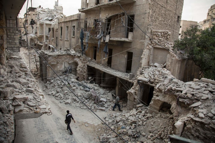 A Syrian man walks past destroyed buildings on May 2, 2016, in Aleppo's Bab al-Hadid neighborhood. The U.S. and Russia agreed to extend a cessation of hostilities to the city Wednesday.