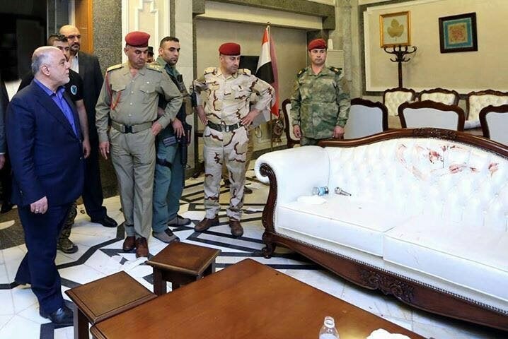 Iraqi Prime Minister Haider al Abadi surveys the damage to a couch in the Iraqi Parliament building after protesters sto