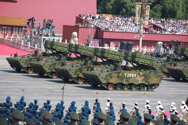 Military vehicles carrying anti-tank missiles drive across Tiananmen Square at a military parade in Beijing. The co