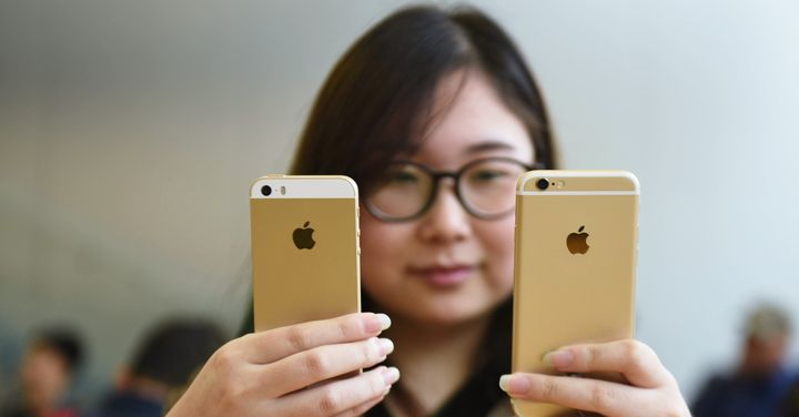 A woman compares two recent iPhones.