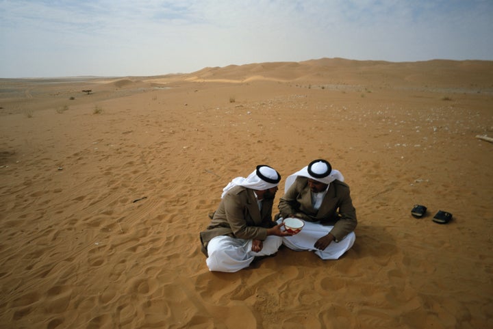 Bedouins of Yam tribe share a bowl of water in the Rub al Khali Desert, in Saudi Arabia.