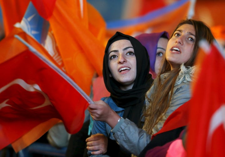 Women wave flags outside AK Party headquarters in Ankara on Nov. 2, 2015. The AK Party regained its parliamentary majority in the Nov. 1 general elections, results Turkish Prime Minister Ahmet Davutoglu described as a victory for democracy.