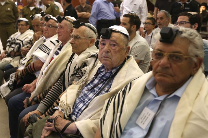 Dozens of Jewish holocaust survivors wear the Tefilin or the Phylacteries and the Tallit prayer shawl.