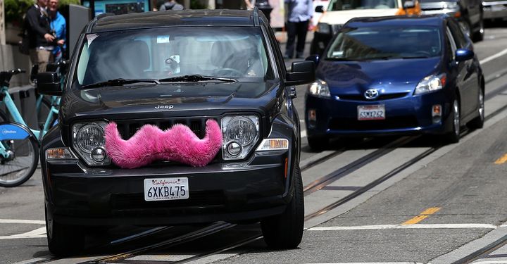 A Lyft car sporting a pink mustache drives along Powell Street in San Francisco. Lyft announced plans Thursday to launch a fleet of self-driving taxis in partnership with General Motors.