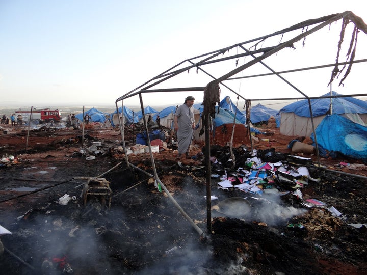 People inspect the damage after airstrikes on the Kamuna refugee camp near the Syrian town of Sarmada on Thursday. Monitoring groups said dozens were killed.