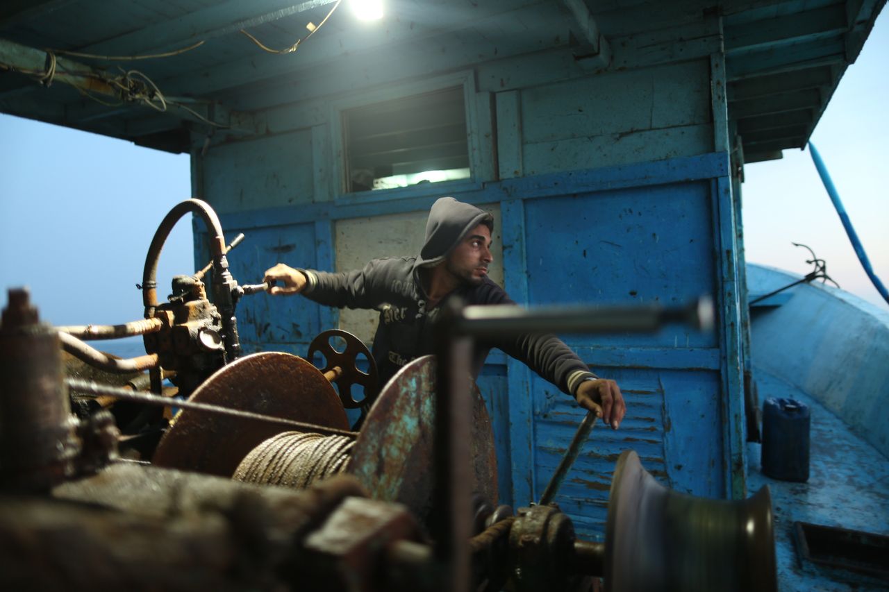 Palestinian fisherman Mohammed Abu Owda prepares to lift fishing nets with the ship's levers on April 3. Photographer Jehad Seftawi accompanied him and his brother Raed on their father's boat.