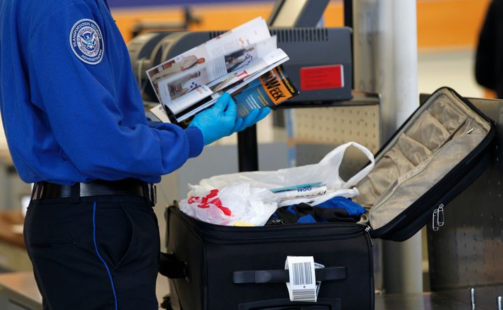 A Transportation Security Administration (TSA) officer inspects items from a piece of luggage at Los Angeles International Airport in Los Angeles, California March 4, 2013.