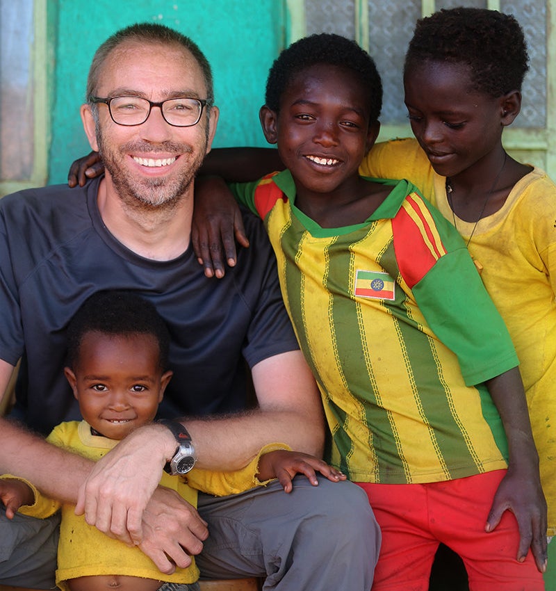 Photographer Alexander Khimushin, creator of "The World In Faces" project, poses with children from Ethiopia.