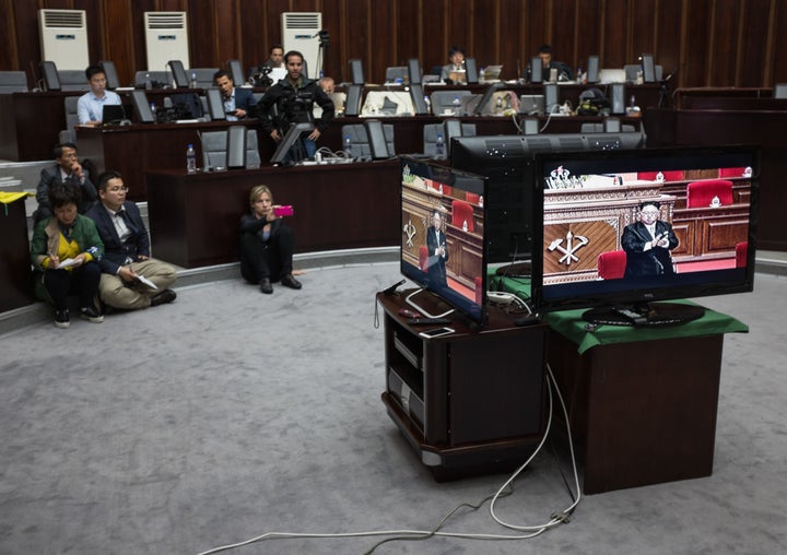Foreign journalists invited to cover the event were not permitted inside the congress. Here, journalists watch a televis