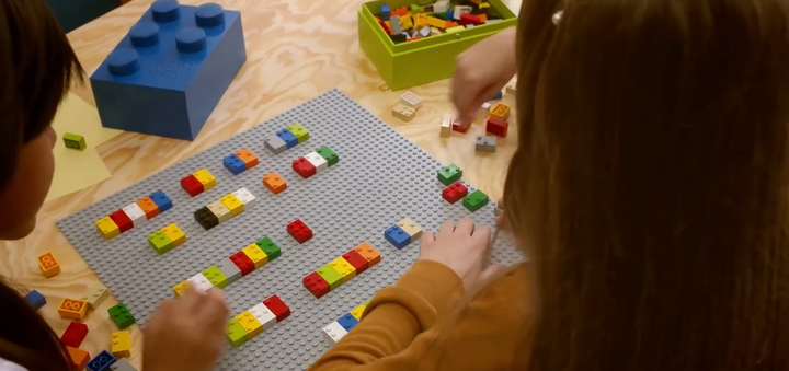 Two kids play with Braille bricks together.