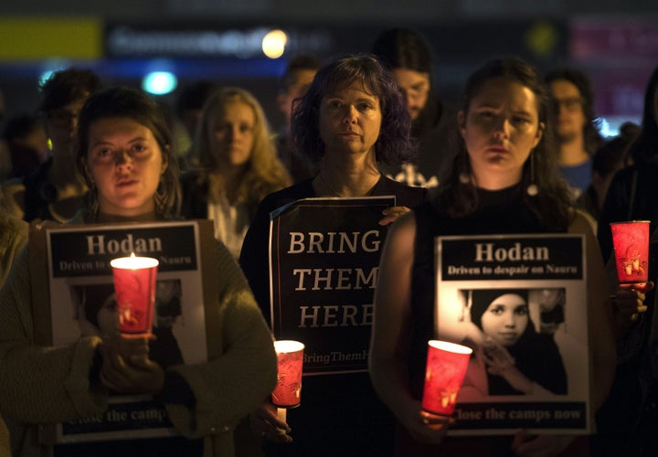 People hold a candlelight vigil in Sydney for two refugees -- a Somali woman and an Iranian man -- who set themselves on fire on the remote Pacific island of Nauru, highlighting Australia's hardline approach to boat-bound migrants.