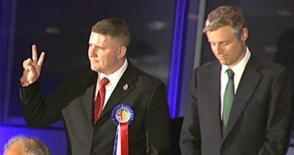 Britain First's Paul Golding (left) does a 'V for Victory' gesture after winning just 31,372 votes, as Zac Goldsmith (right) looks on.