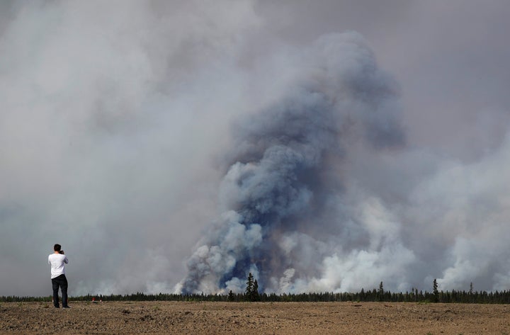 A man takes a photograph of the wildfires near Fort McMurray, Alberta, Canada, May 6, 2016.