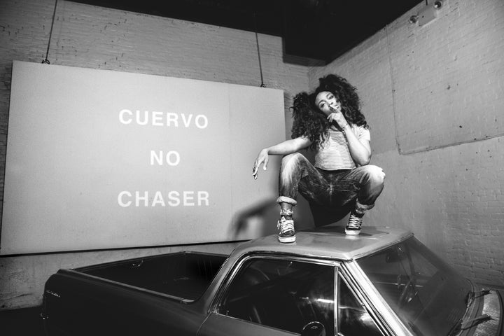 SZA, who was rocking her signature natural curls for her Brooklyn show, crouched atop a car to pose for a photo.