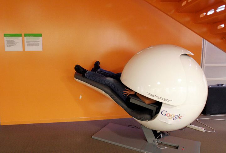 An employee takes a nap in a nap pod which blocks out light and sound at the Google headquarters in Mountain View, California