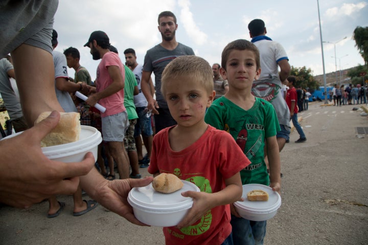 Syrian migrant children hold their food portion at the Kara Tepe refugee camp.