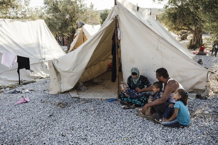 A Syrian refugee family sits outside their tent in the Kara Tepe refugee camp.