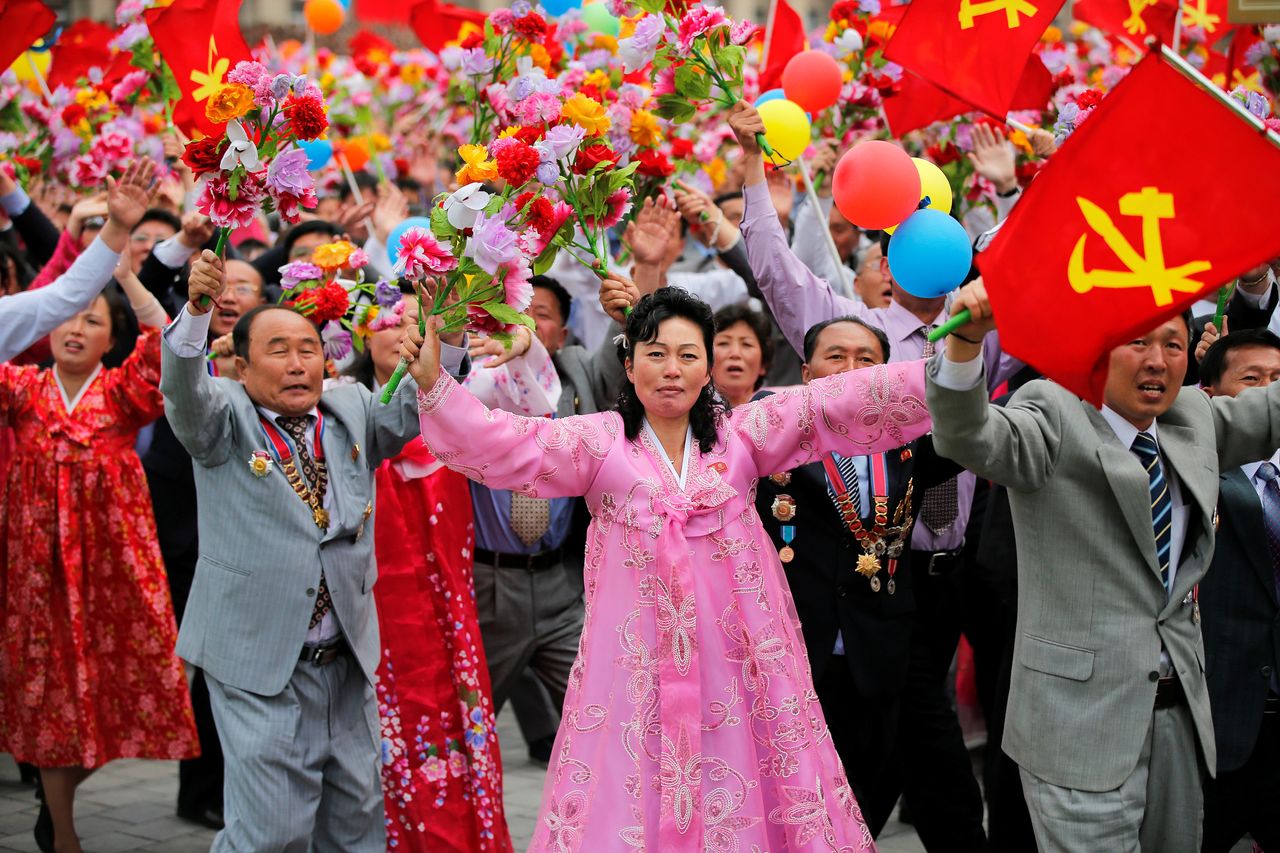 They waved pink flowers as they passed before Kim and other top officials on a leaders' platform at Tuesday's parade.