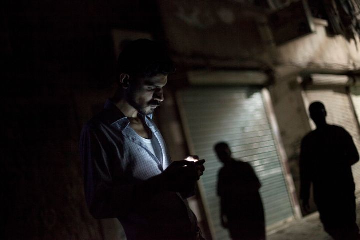 A man looks at his mobile phone in the Bustan al-Qasr neighborhood of Aleppo in Septmber 2012.