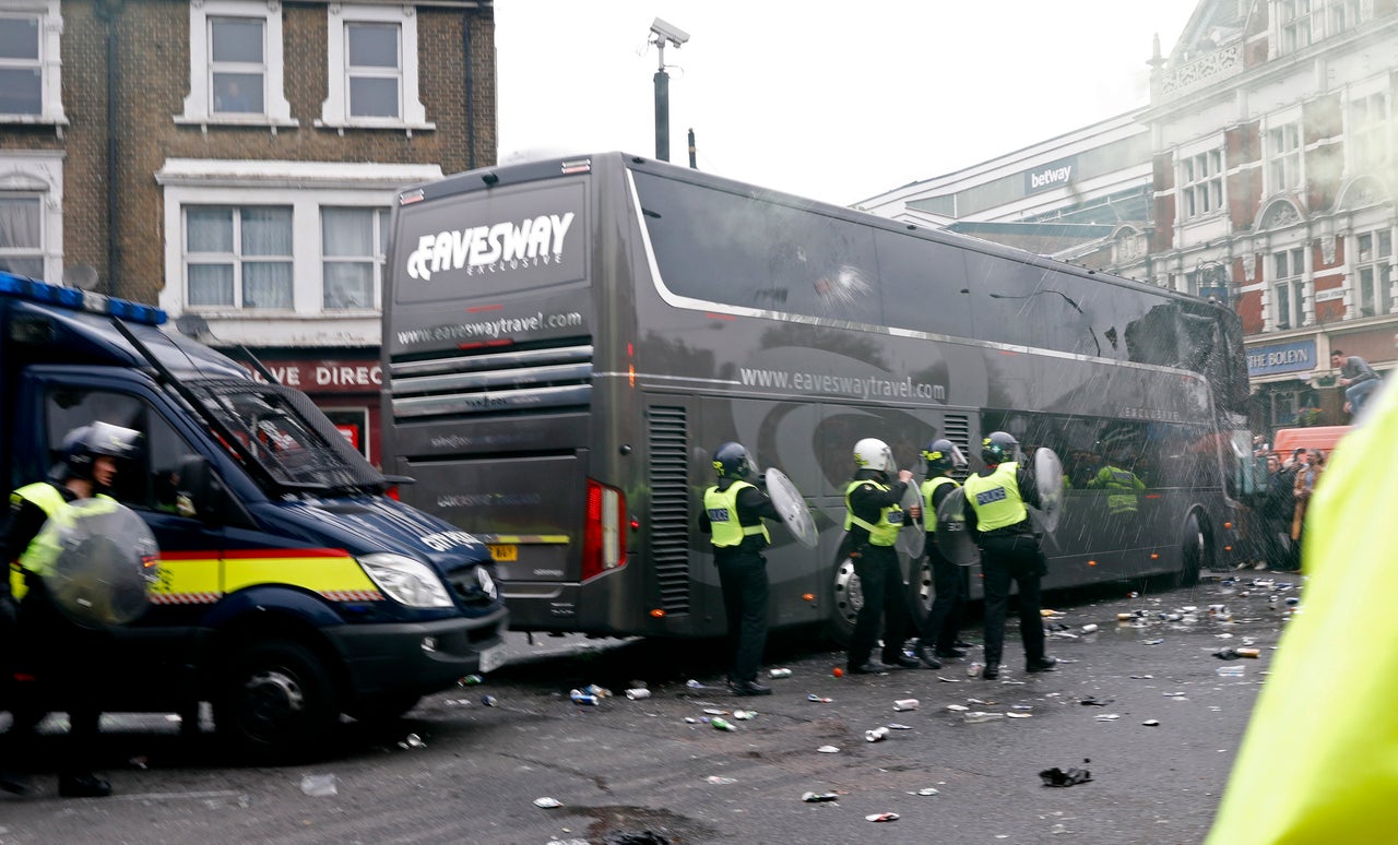 Riot police guard the team bus from rioting football fans