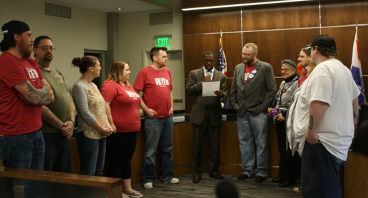 Waterloo Mayor Quentin Hart, center, reads a proclamation declaring May 5 a Day of Reason, following a secular invocation delivered by Justin Scott, right.