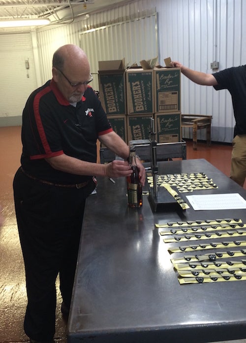 Fred Noe, Jim Beam master distiller, on Tuesday, May 10, places a label on the first bottle of Booker's Rye, a 13-year-old uncut rye whiskey, which his father, Booker Noe, barreled in 2003.