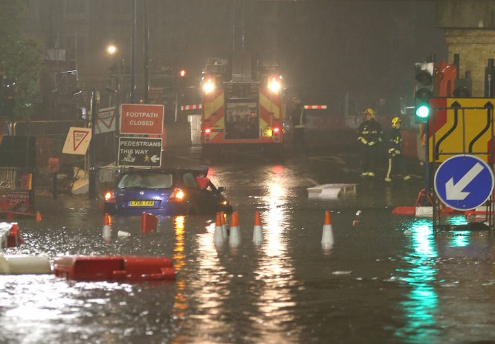 A motorist struggles with the floodwater