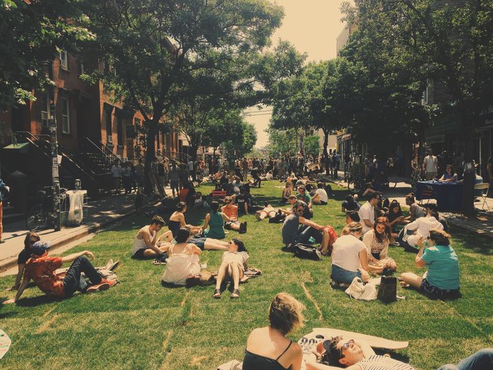 Attendees of a 2014 summer festival lounge on the grass in Williamsburg, a formerly low-income neighborhood that has seen rent increases, income growth, and a declining minority population over the last couple of decades.