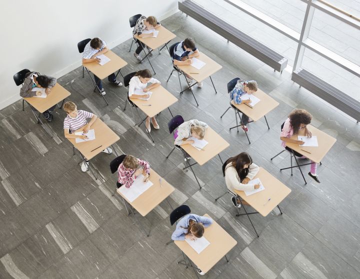 Students taking a test in classroom Compassionate Eye Foundation/Martin Barraud via Getty Images