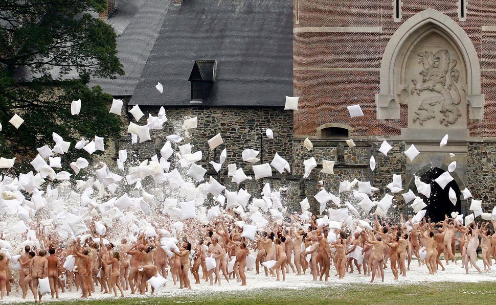 Naked volunteers battle with pillows as they pose for U.S. artist Spencer Tunick in front of the Gaasbeek's Castle on July 9,