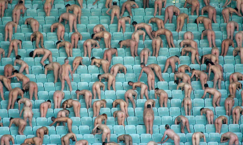 People pose during a performance at the Ernst Happel soccer stadium in Vienna on May 11, 2008. About 1,800 people stripped na