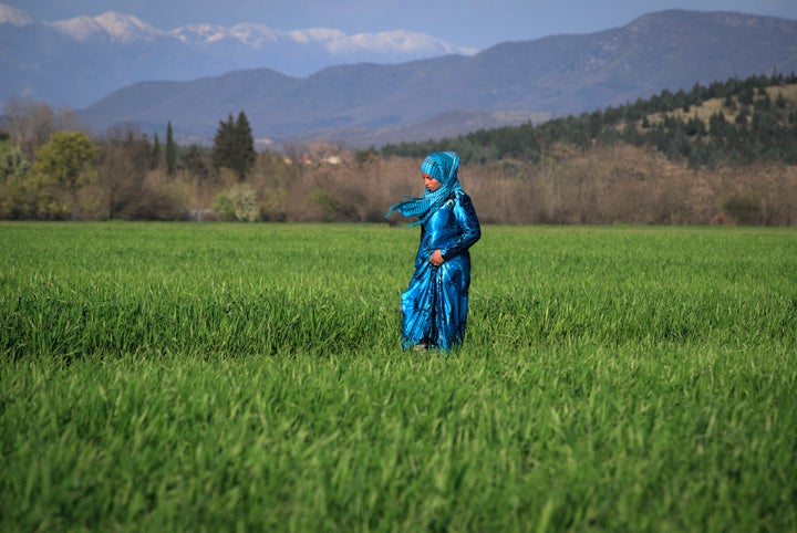 A woman walks in a field in Idomeni. Education is in high demand for Syrian refugees.