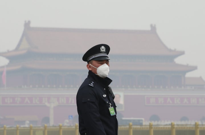 A security officer wearing a mask stands in haze in Beijing, China.